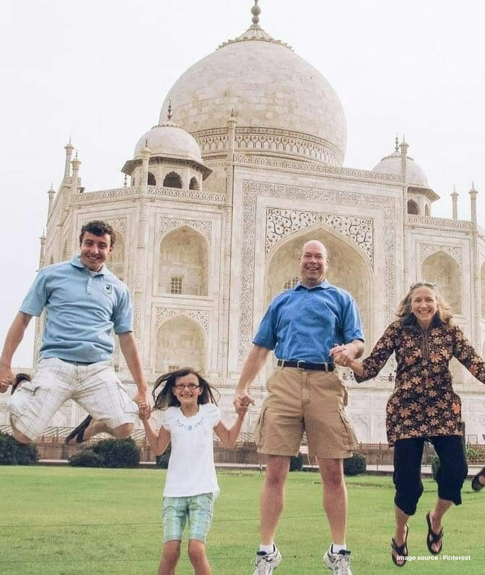 a family with a kid jumping in joy in front of the taj mahal
