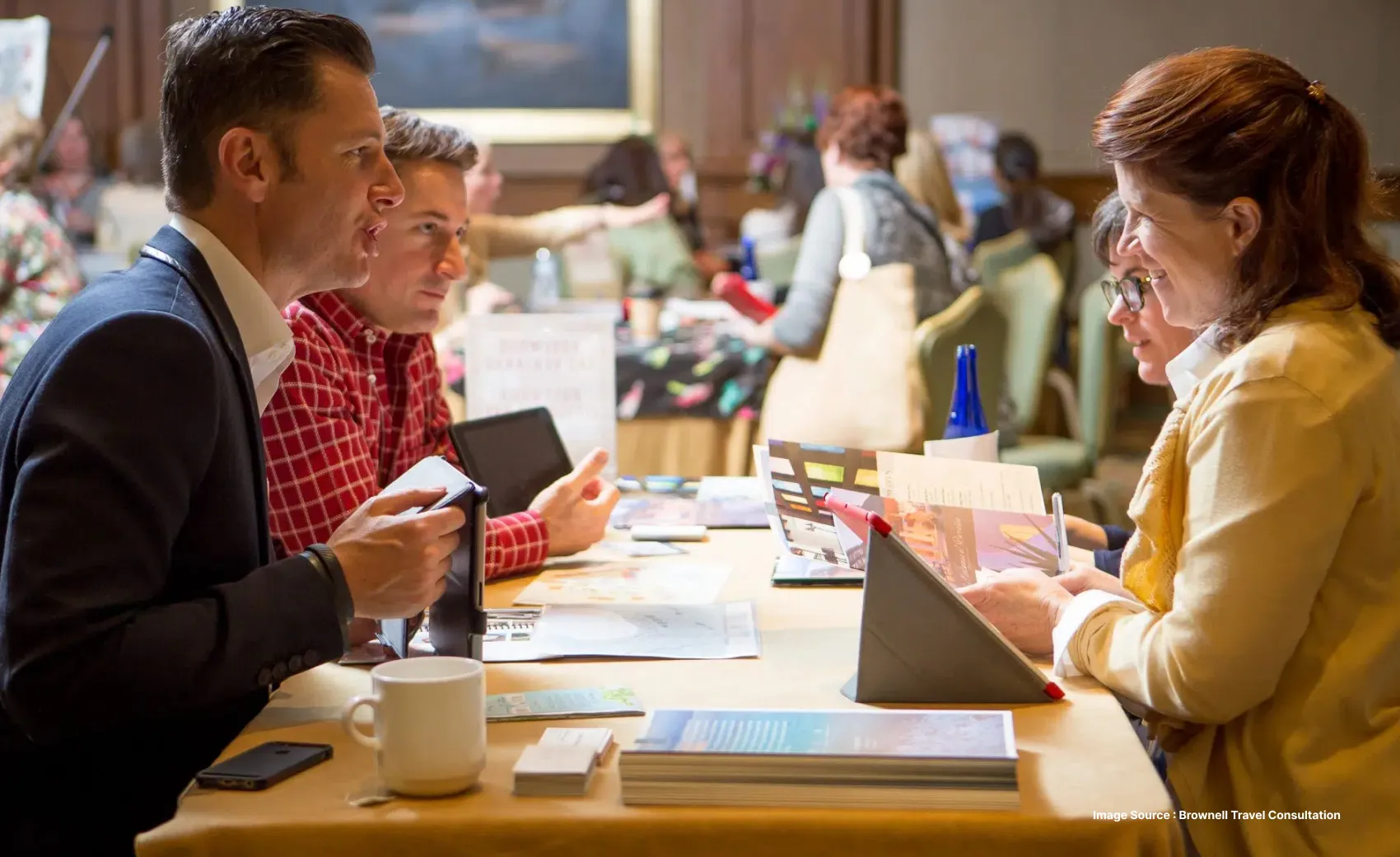 two white men discussing with two white women at a travel advisors meet