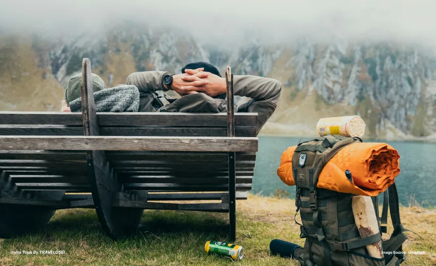 A man relaxing with a backpack next to him