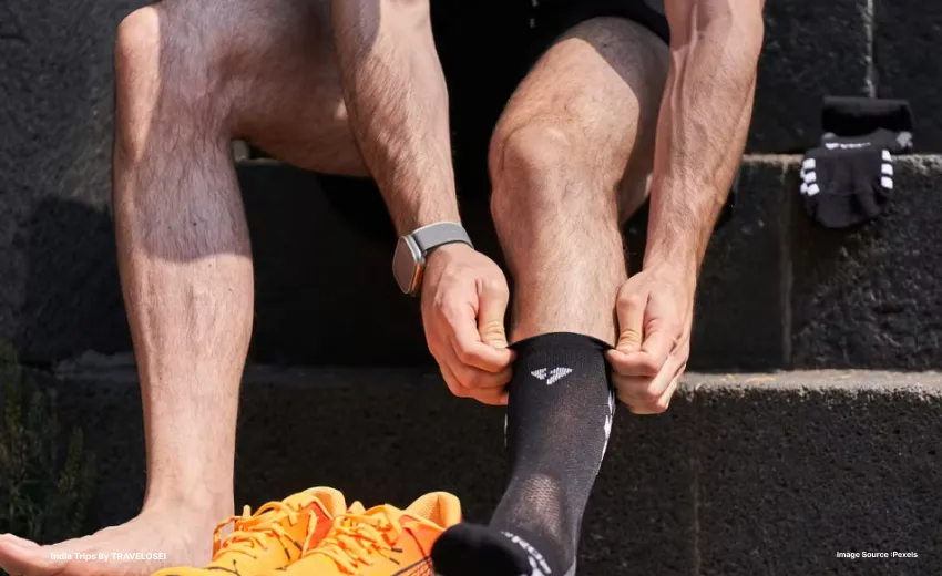 somebody putting their socks on before wearing yellow shoes