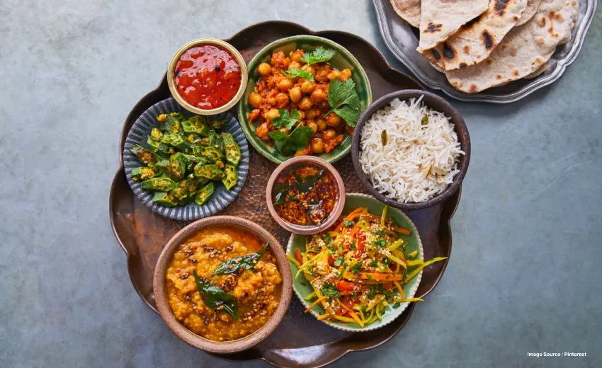 a visually pleasing north indian food platter with chickpea curry, dips and some naan