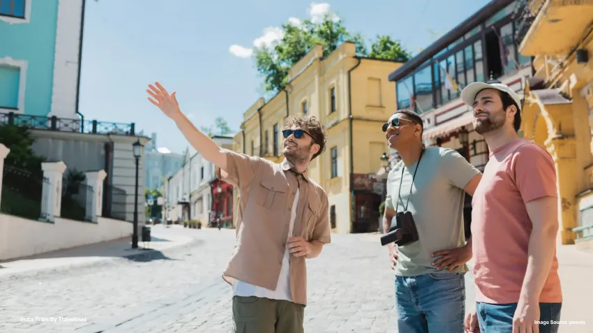 3 men standing together with one of them pointing to something that's at a distance3 men standing together with one of them pointing to something that's at a distance