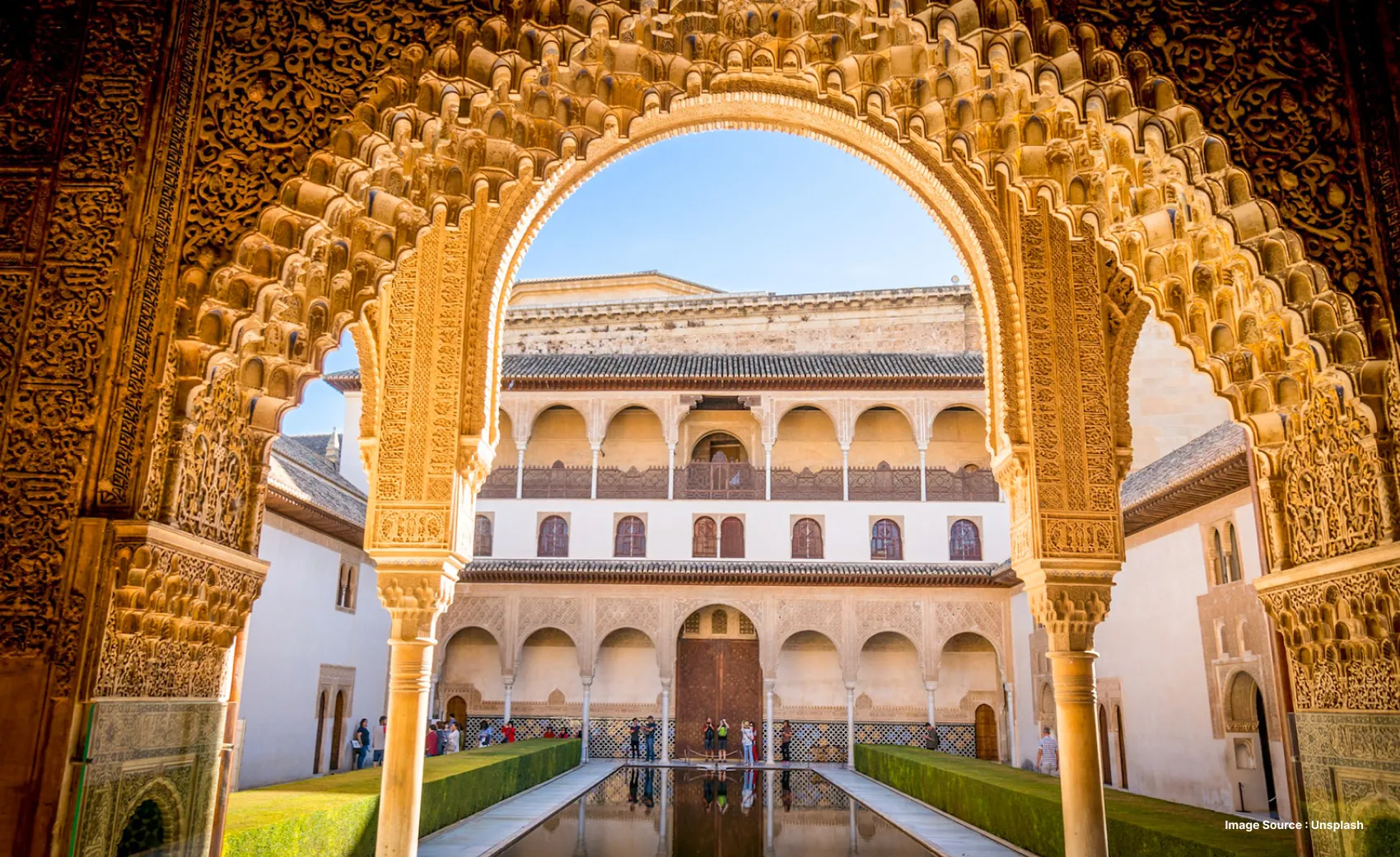 an impressively detailed archway opening up to a courtyard with beautiful architecture