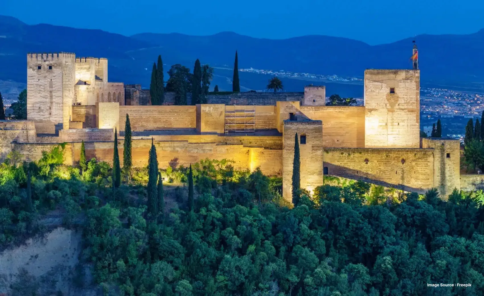 lush greenery surrounding a part of the alhambra palace at night