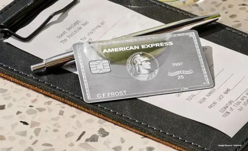 a silver american express on top of a bill with a silver pen