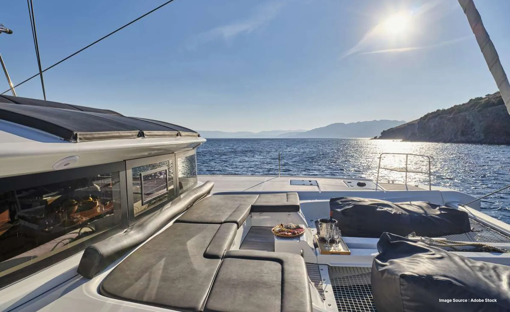 view of a luxurious yacht deck with lounging seats and food on a sunny day
