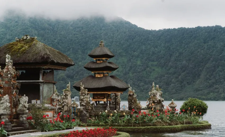 Traditional lakeside temple surrounded by misty mountain landscapes