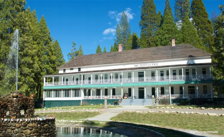 a serene property with a fountain in front and a staircase leading up to the cottage like 3-storey hotel