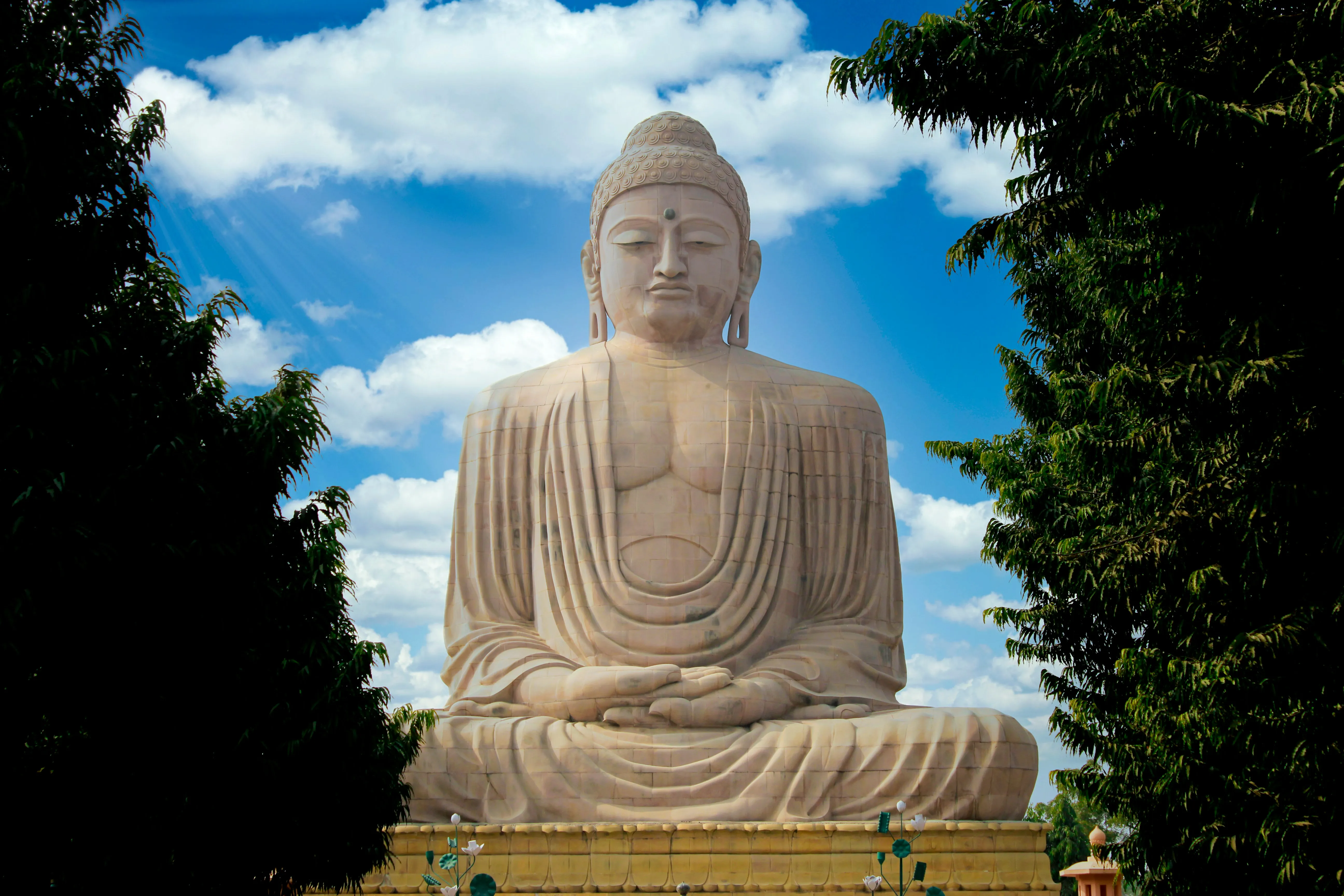 the grey massive statue of lord buddha in bodhgaya on a sunny day