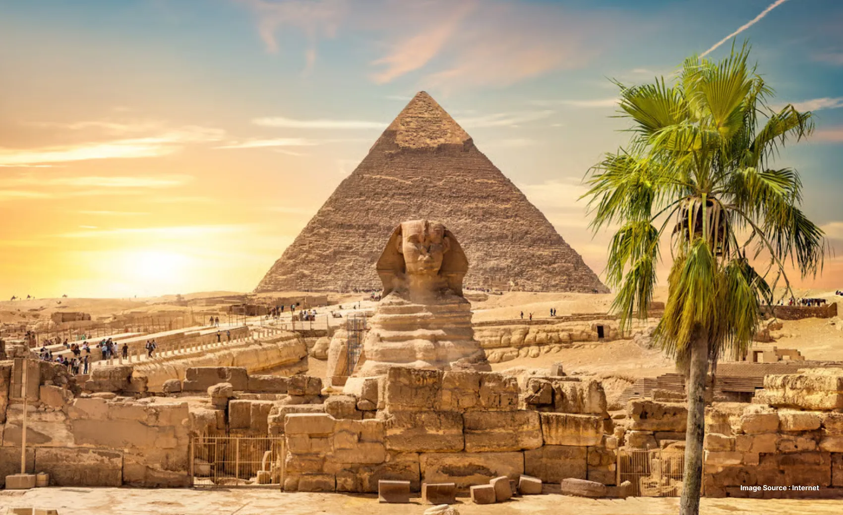 the great sphinx and pyramid in cairo at sunset as tourists explore the deserty grounds