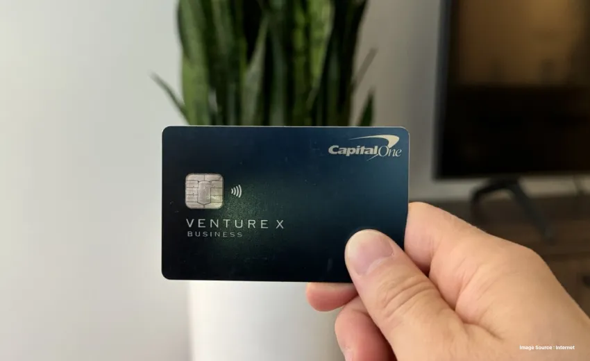 a person holding up a venture card with a snake plant pot in the background