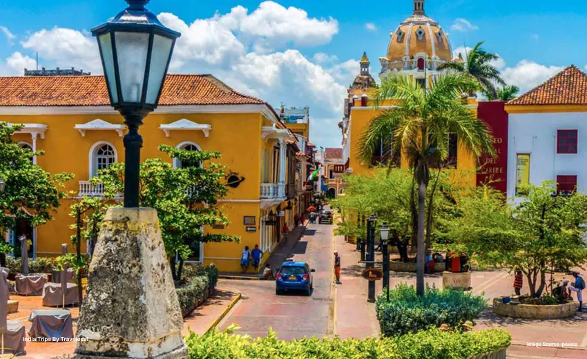 An image of a road and a car is on the road inbetween buildings built with traditional architecture