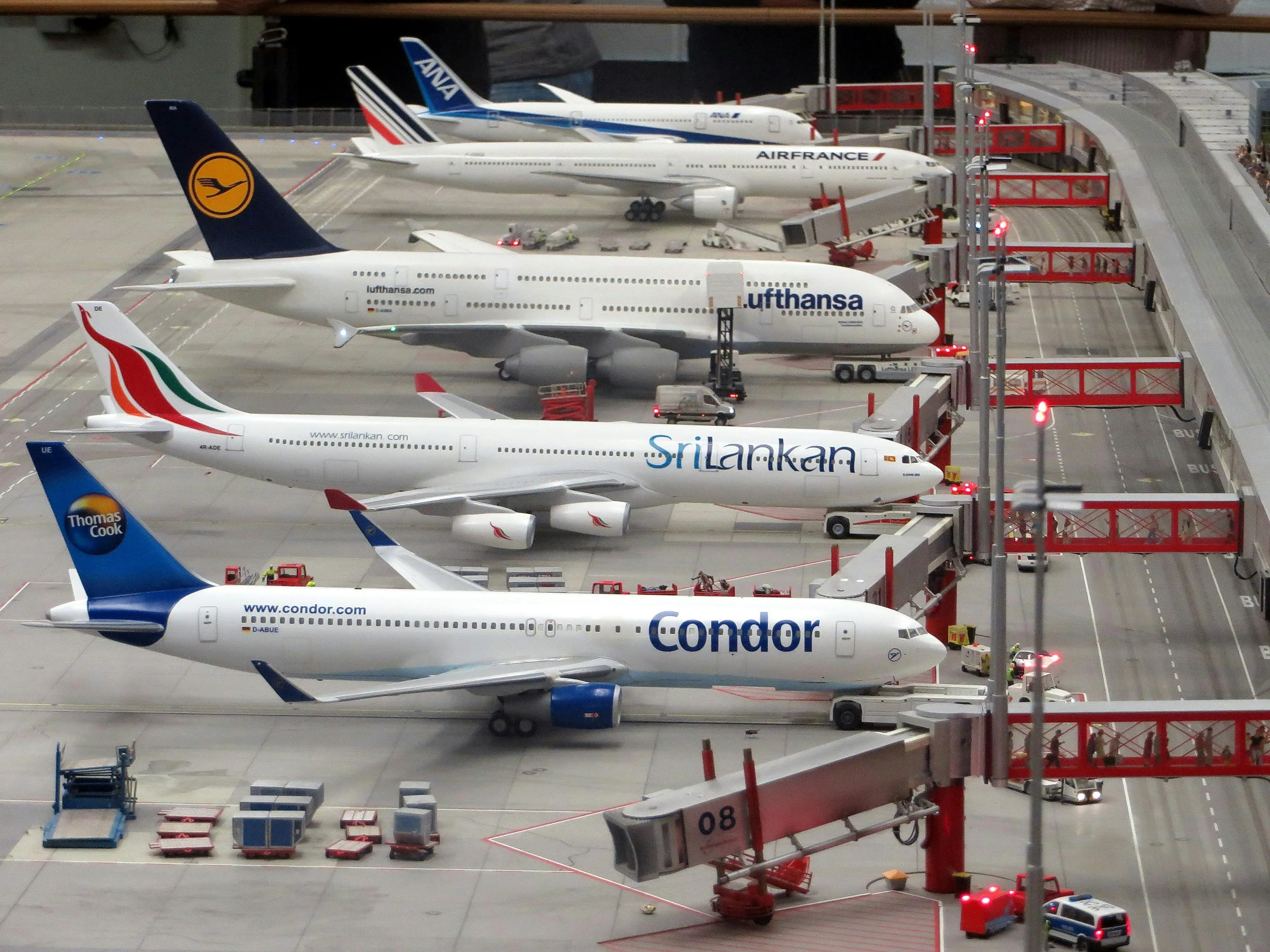 A fleet of airplanes standing in a hangar, where first in line is a Condor airline's plane