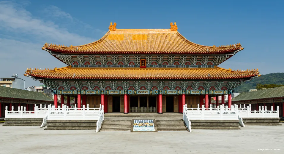 a chinese temple with golden tiled roofs and red pillars on a clear day