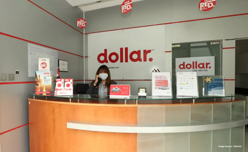 a receptionist on call wearing a white mask at the dollar car rental outlet