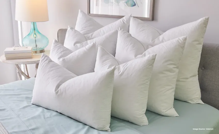 a stack of white luxury hotel pillows on bed