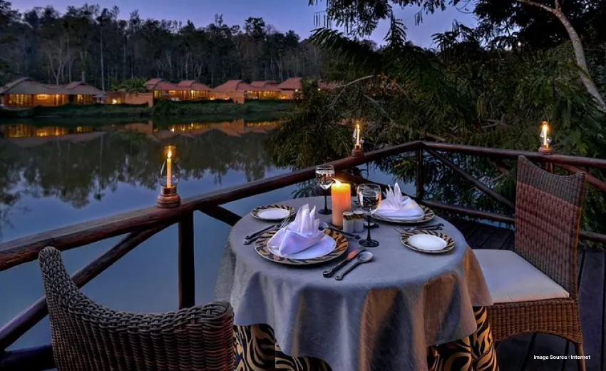 a romantic candlelight dinner setup by the cauvery river at sunset