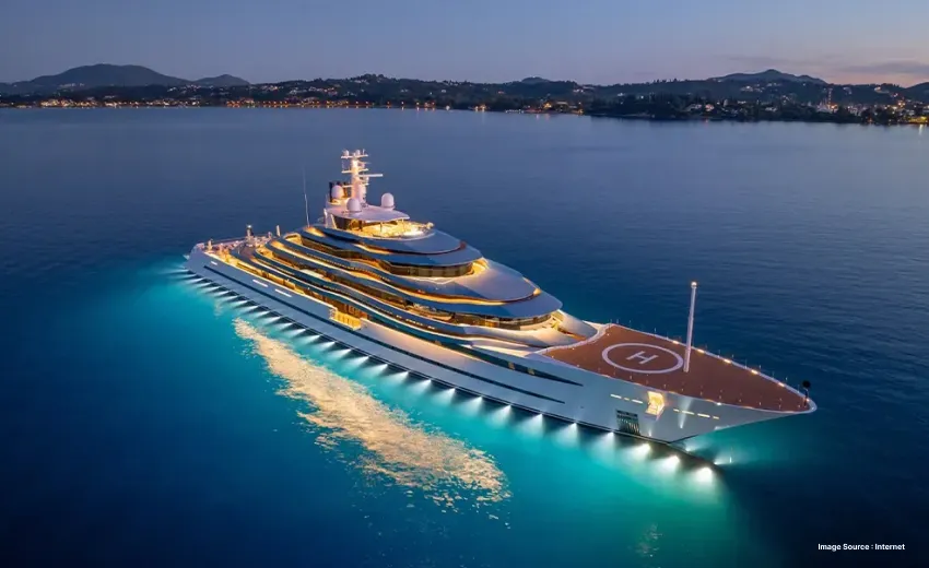aerial view of a brightly lit superyacht with a helipad during sunset