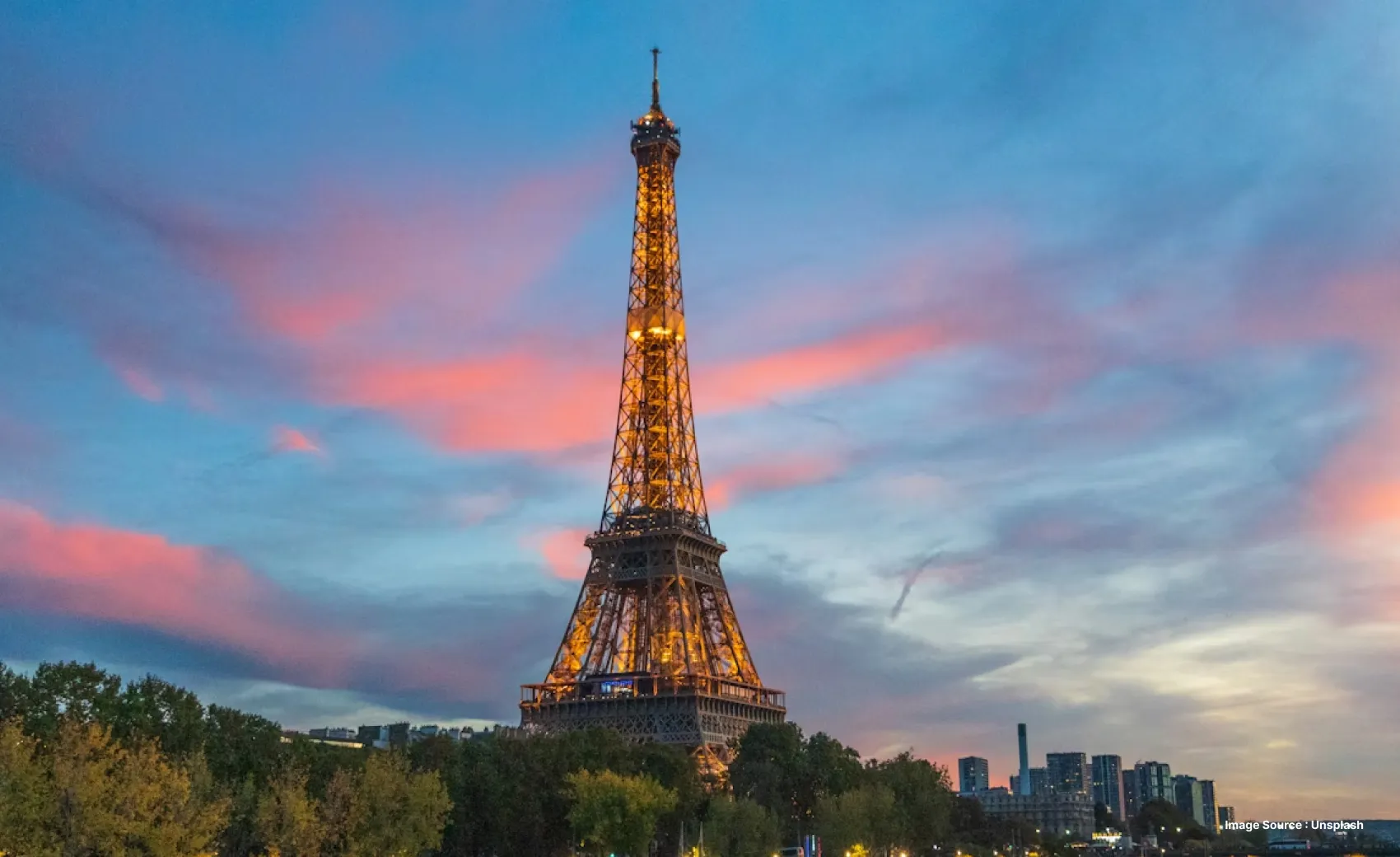 Sunset view of Eiffel Tower with the monument lit up in golden lights
