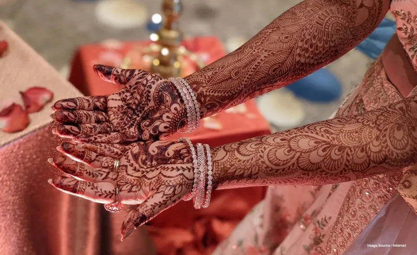 a beautiful henna design on a bride's hands with bangles on the wrists