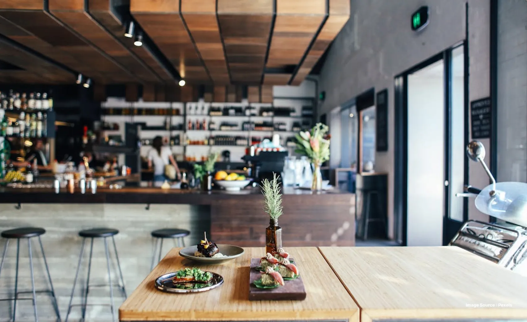 a three course meal served at a wooden table with a bustling cafe background