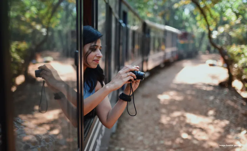 Traveler capturing scenic views from a moving train journey