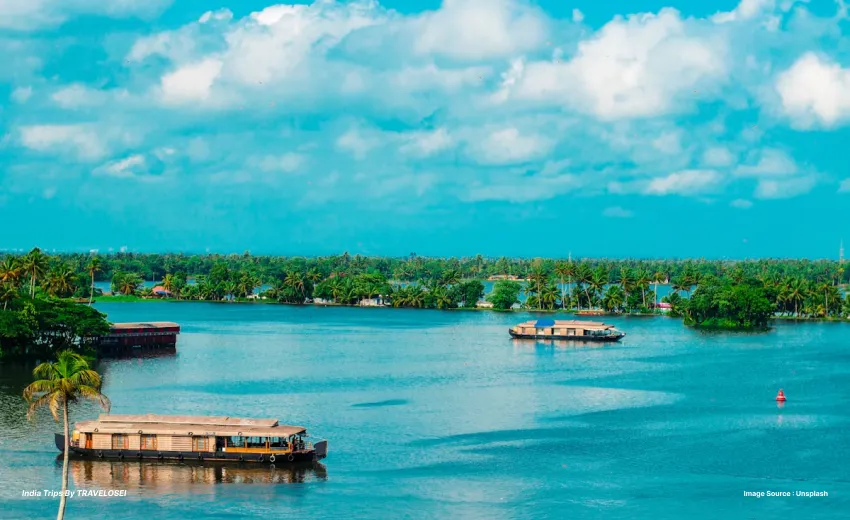 An image of the kerala backwaters, with 2 boats in the middle of the water.