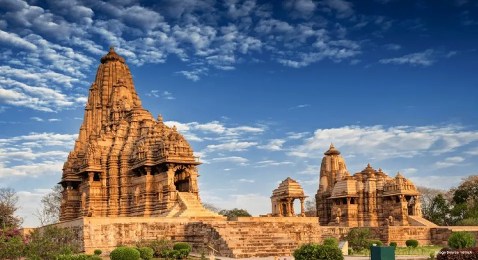 distant view of the ancient sculpture temples in khajuraho, covered with trees on a clear day