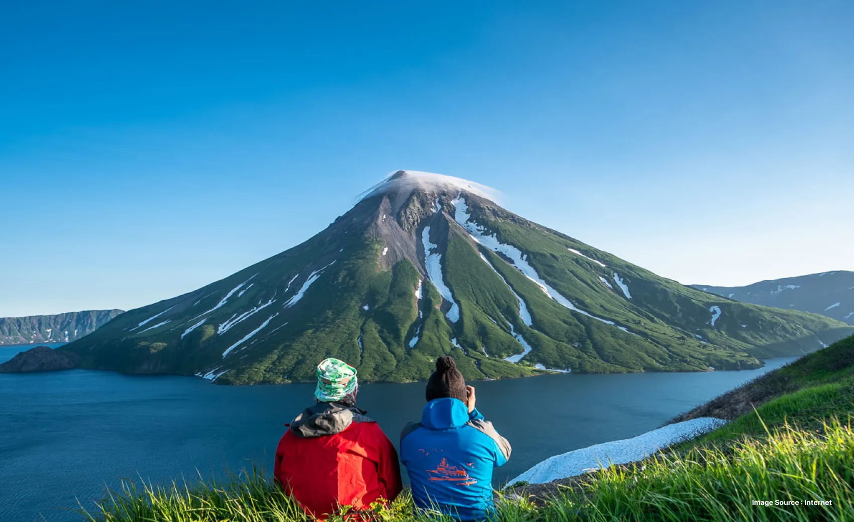 two hikers enjoying the view of kuril islands with clear blue waters and greenery