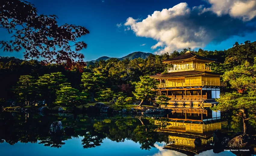 Traditional Golden pavilion reflected in a serene lakeside garden.