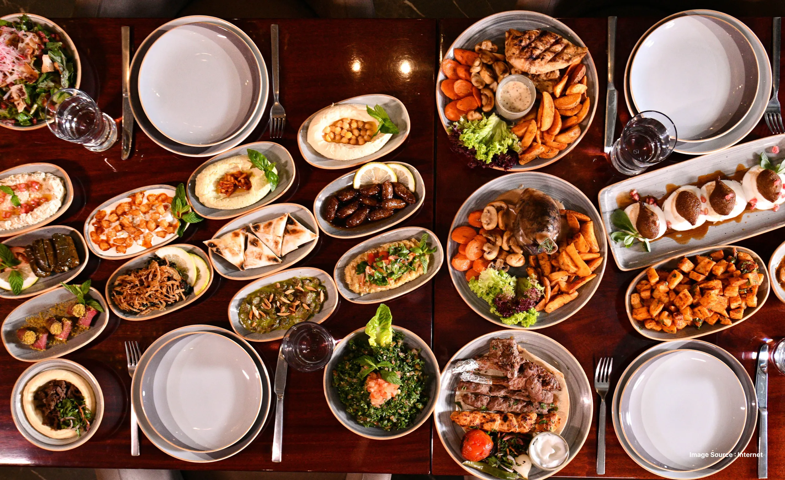 an appetizing spread of Lebanese food with fresh vegetables & dips, set up with white cutlery