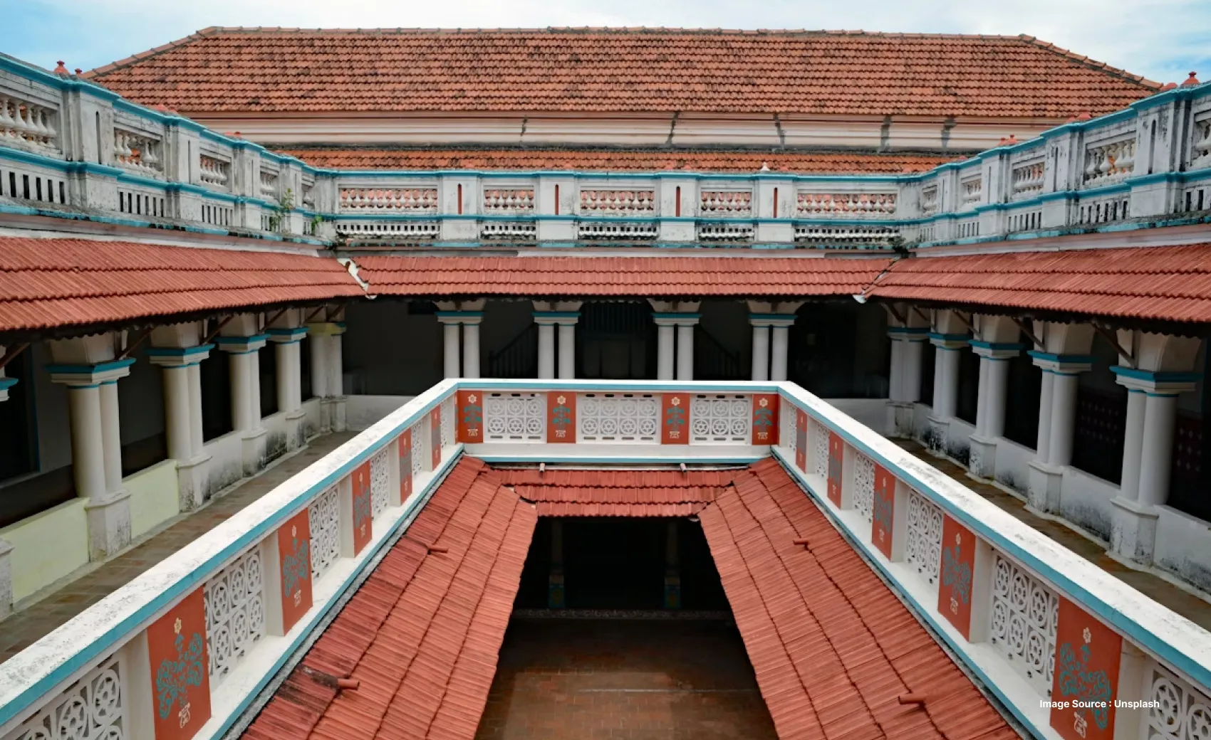 an ancient mansion in chettinad with unique red tiled roofs and intricate railings
