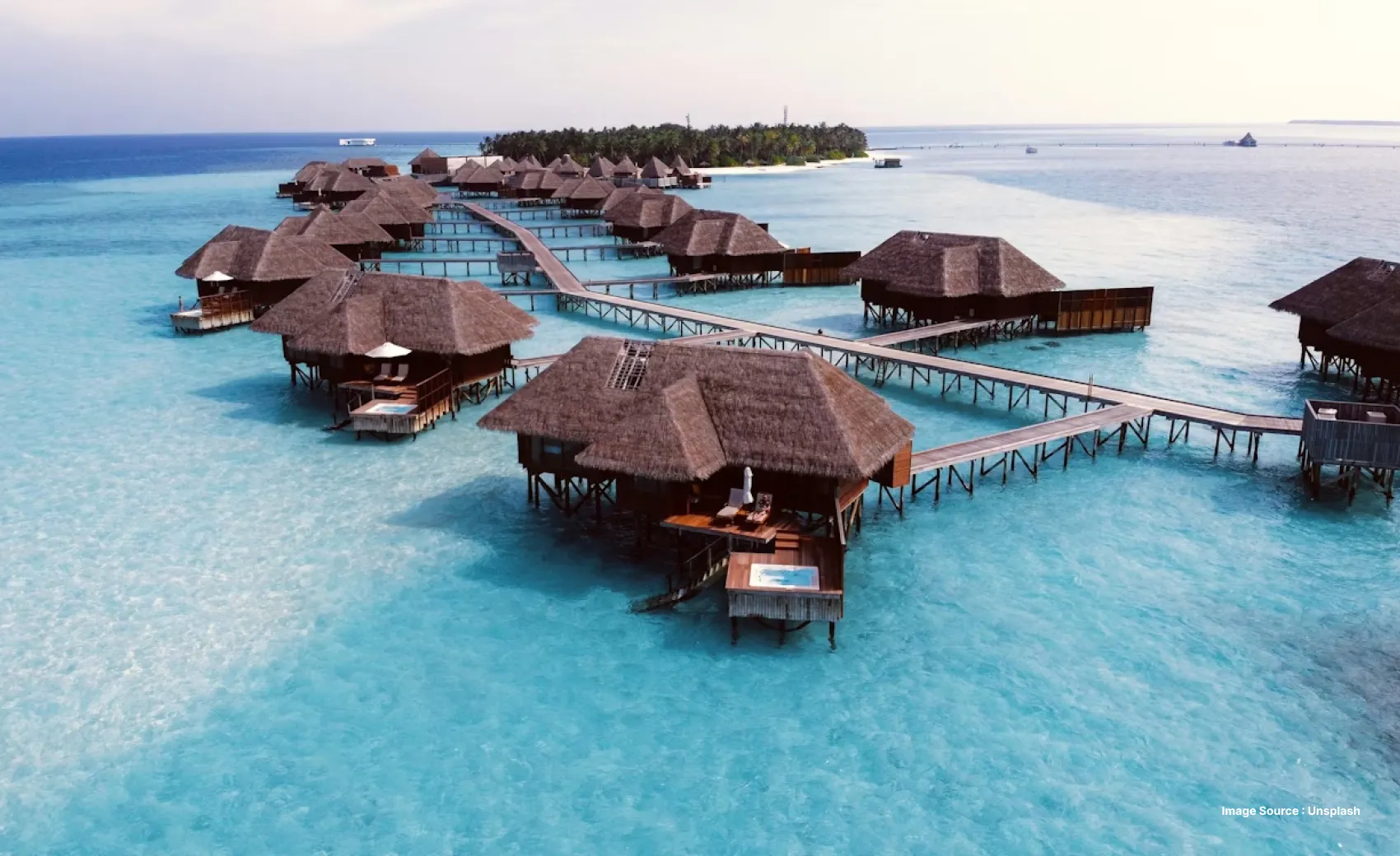 overwater resort in maldives with brown roofs and a pesonal pool for each stay