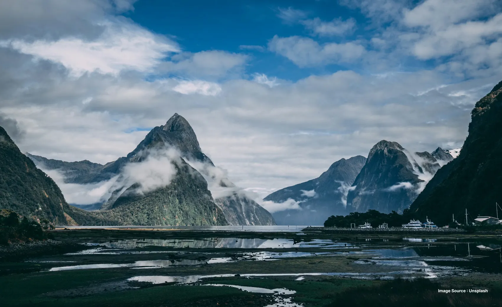 enchanting mountains with low lying clouds and a group of water springs on a cloudy day
