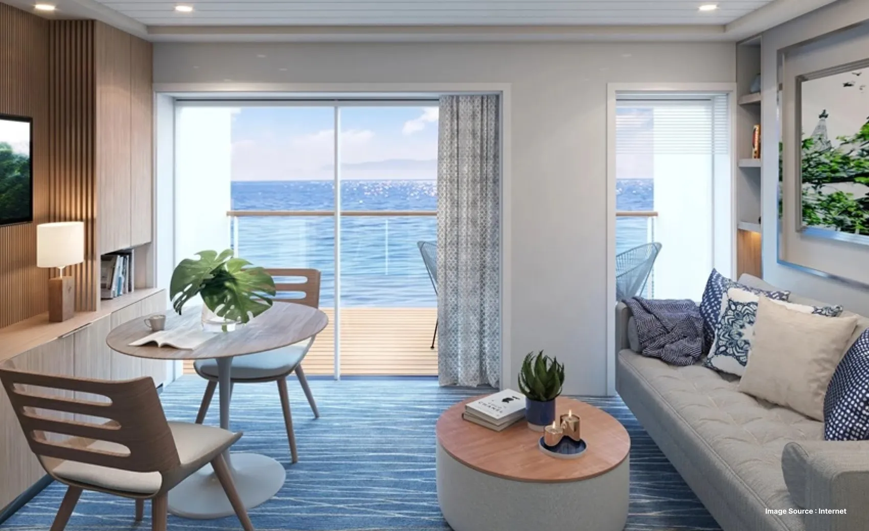 inside view of a luxurious cabin on a cruise decorated with plants and lounge chairs and equipped with wooden furniture and a tv