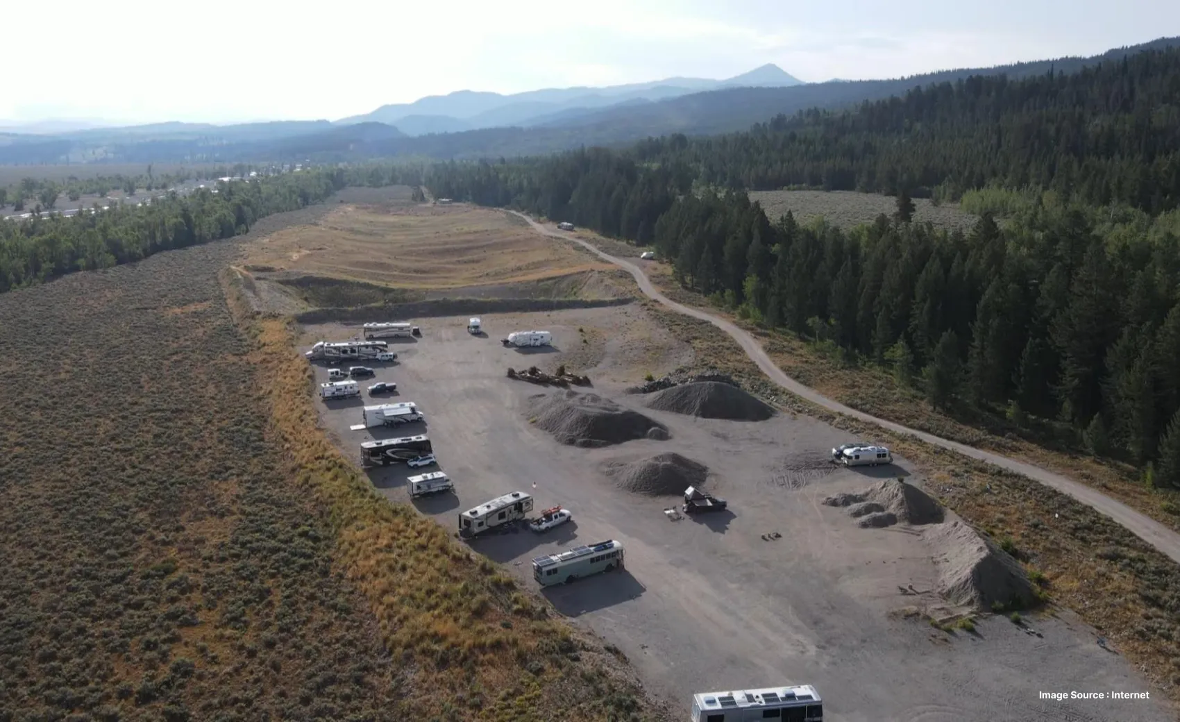 aerial shot of dispersed camping in spread creek witih many vans on a plain rugged land