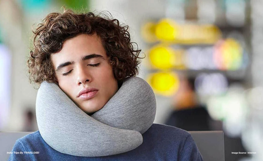 a picture of someone waiting at an airport gate with a neck pillow around their neck
