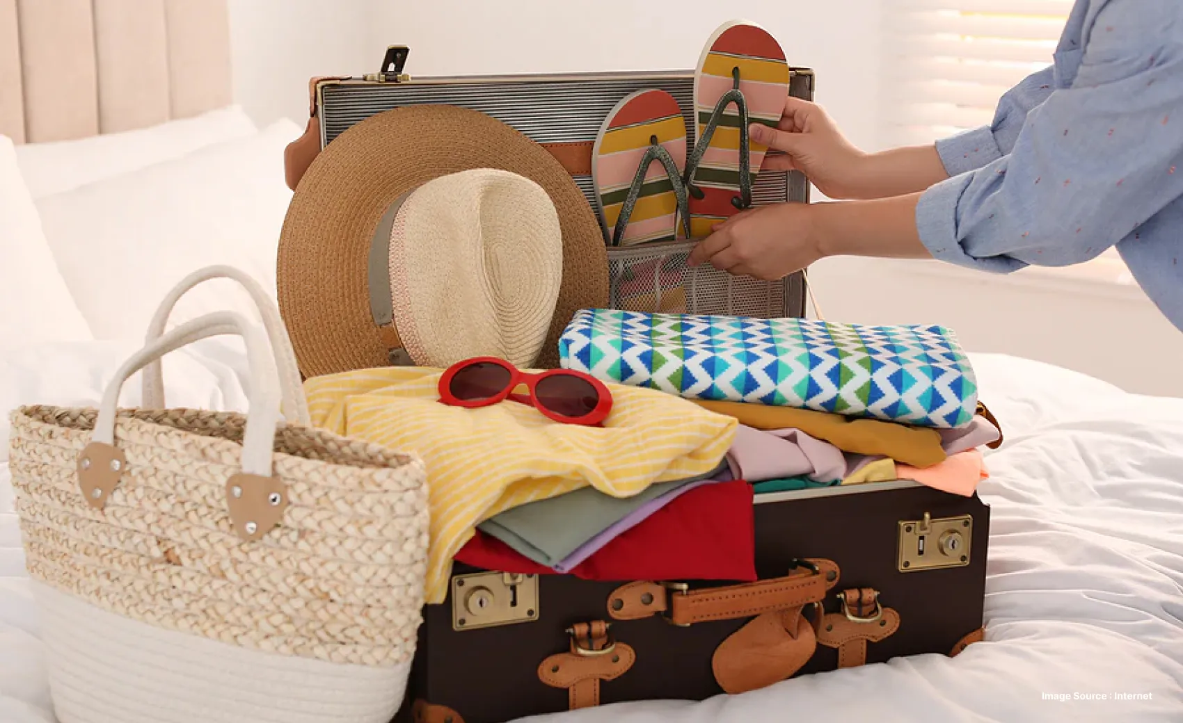 packing items for beach vacation including a beach bag, hat, slippers