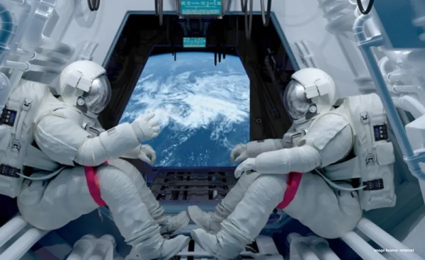two astronauts in full equipment sat inside the international space station