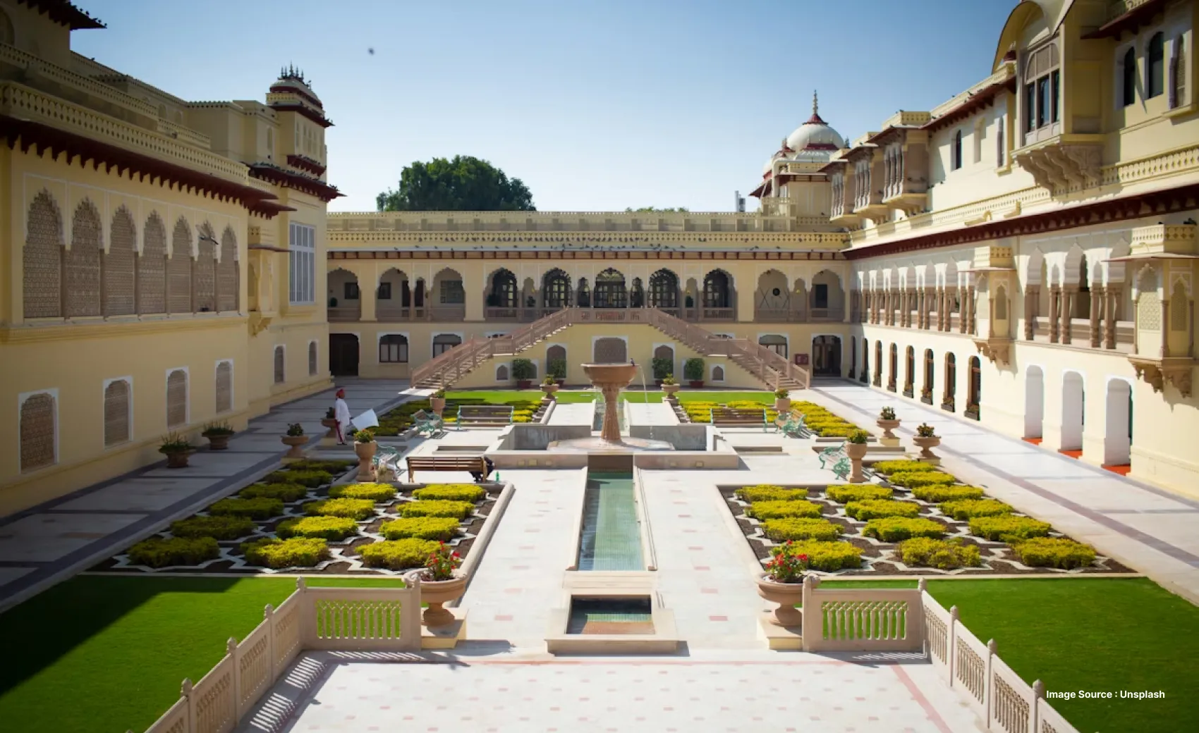 the manicured garden patches shaped like flowers in the courtyard of rambagh palace in jaipur