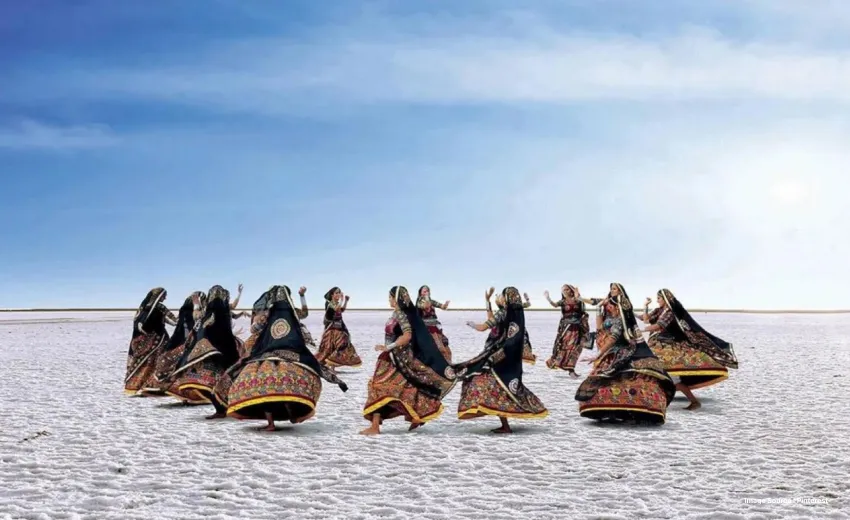 traditionally dressed ladies dance in a circl in the white salt desert