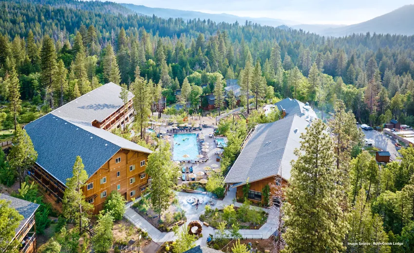 aerial shot of a modern wooden lodge with three storeys and a swimming pool in between