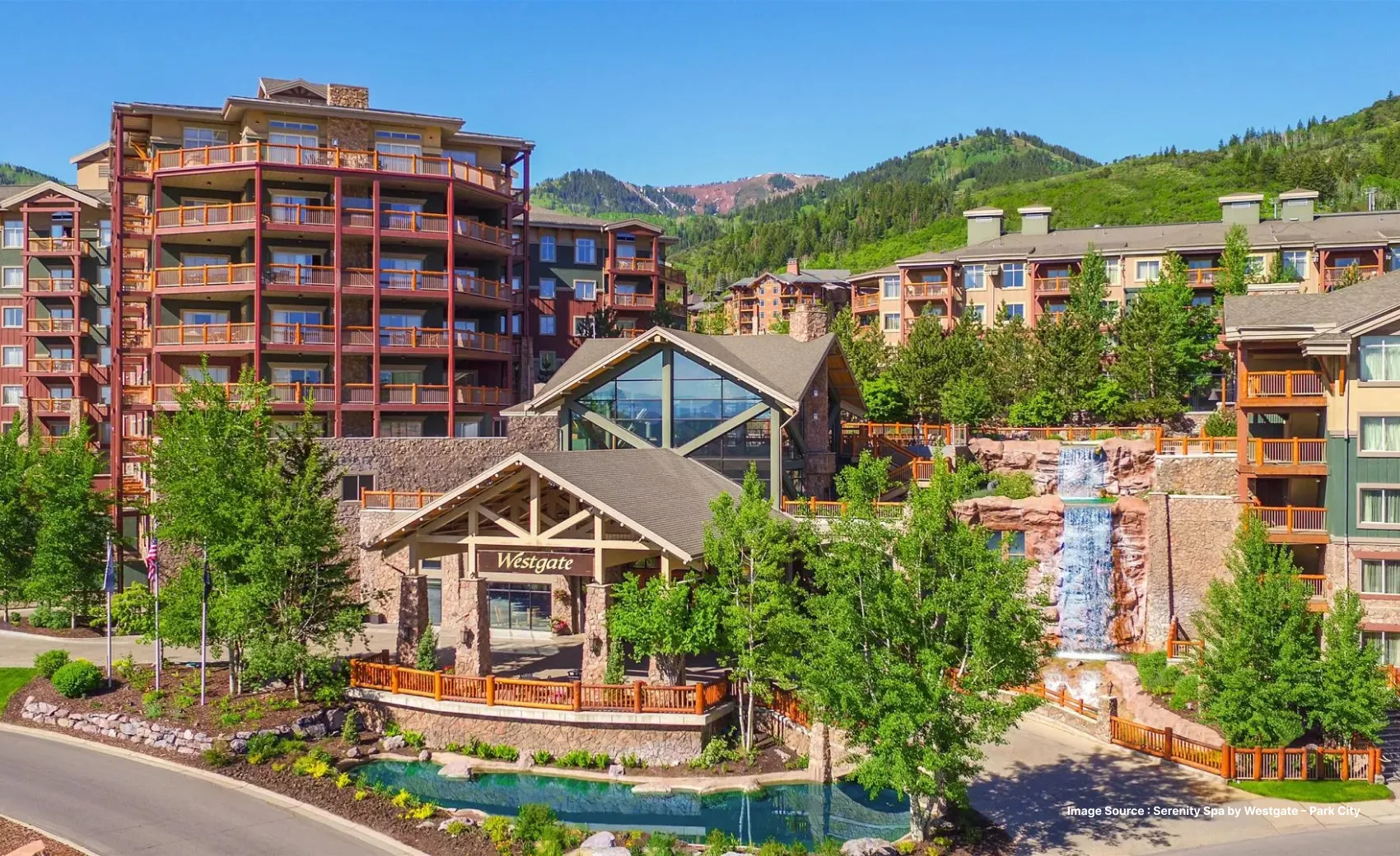 a daytime summer season view of the westgate park city resort with a decorative pool in the front