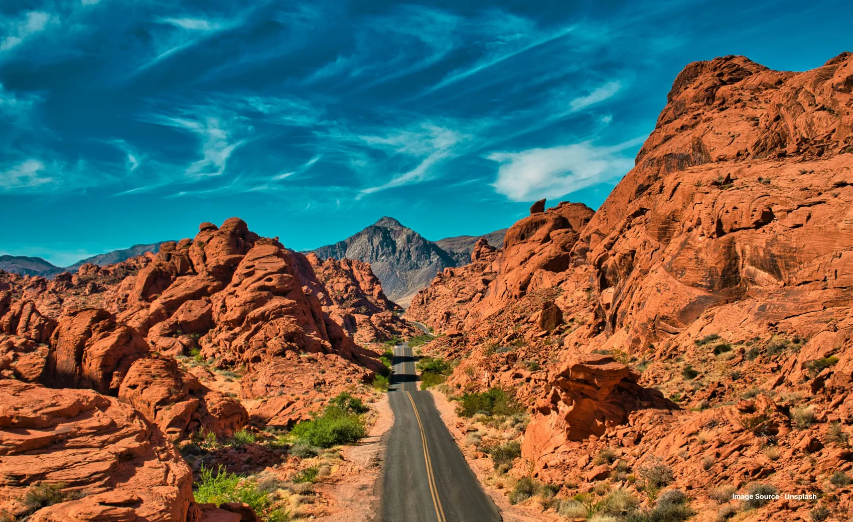 nevada highway road on a clear sunny day surrounded by valley of fire cliffs