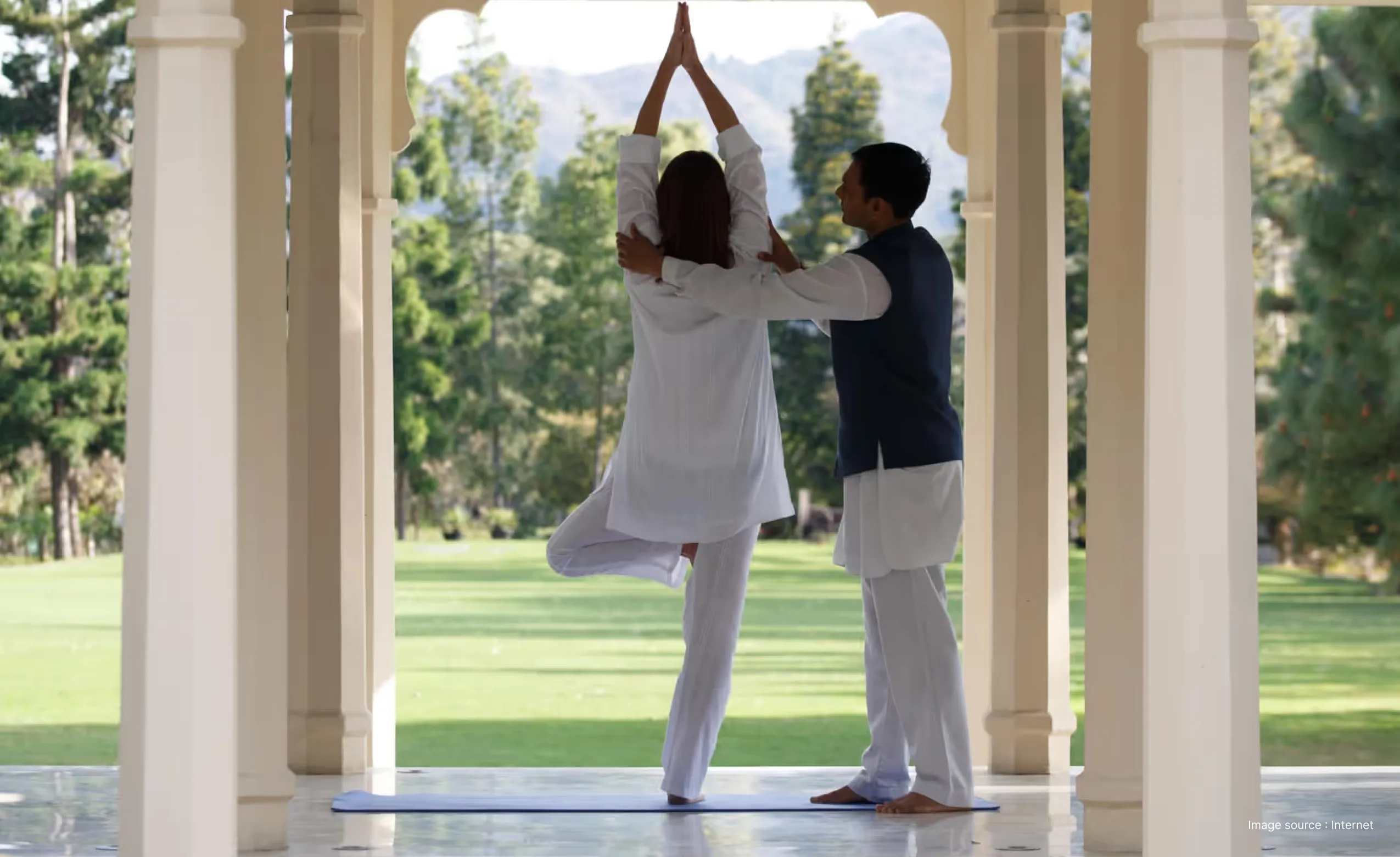 instructor correcting yoga pose at a wellness resort