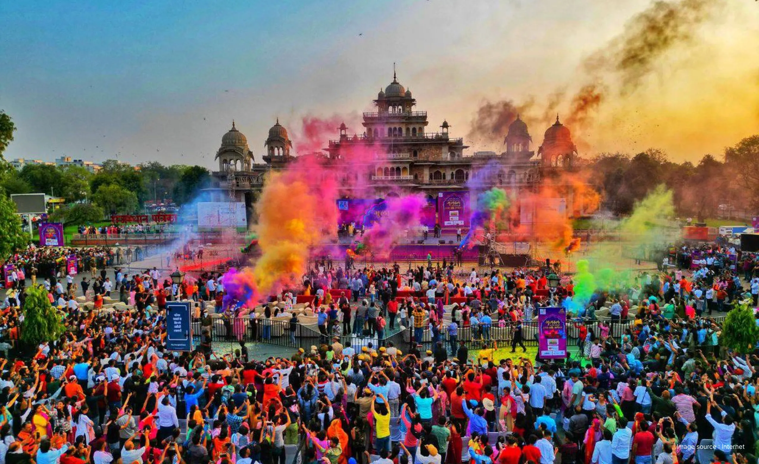 aerial shot of holi celebration with a large crowd at the albert hall museum in jaipur as colors are thrown in the air