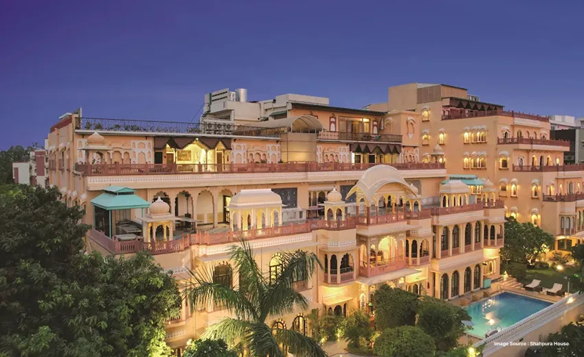 Luxury heritage-style hotel illuminated at night with pool and courtyard views.