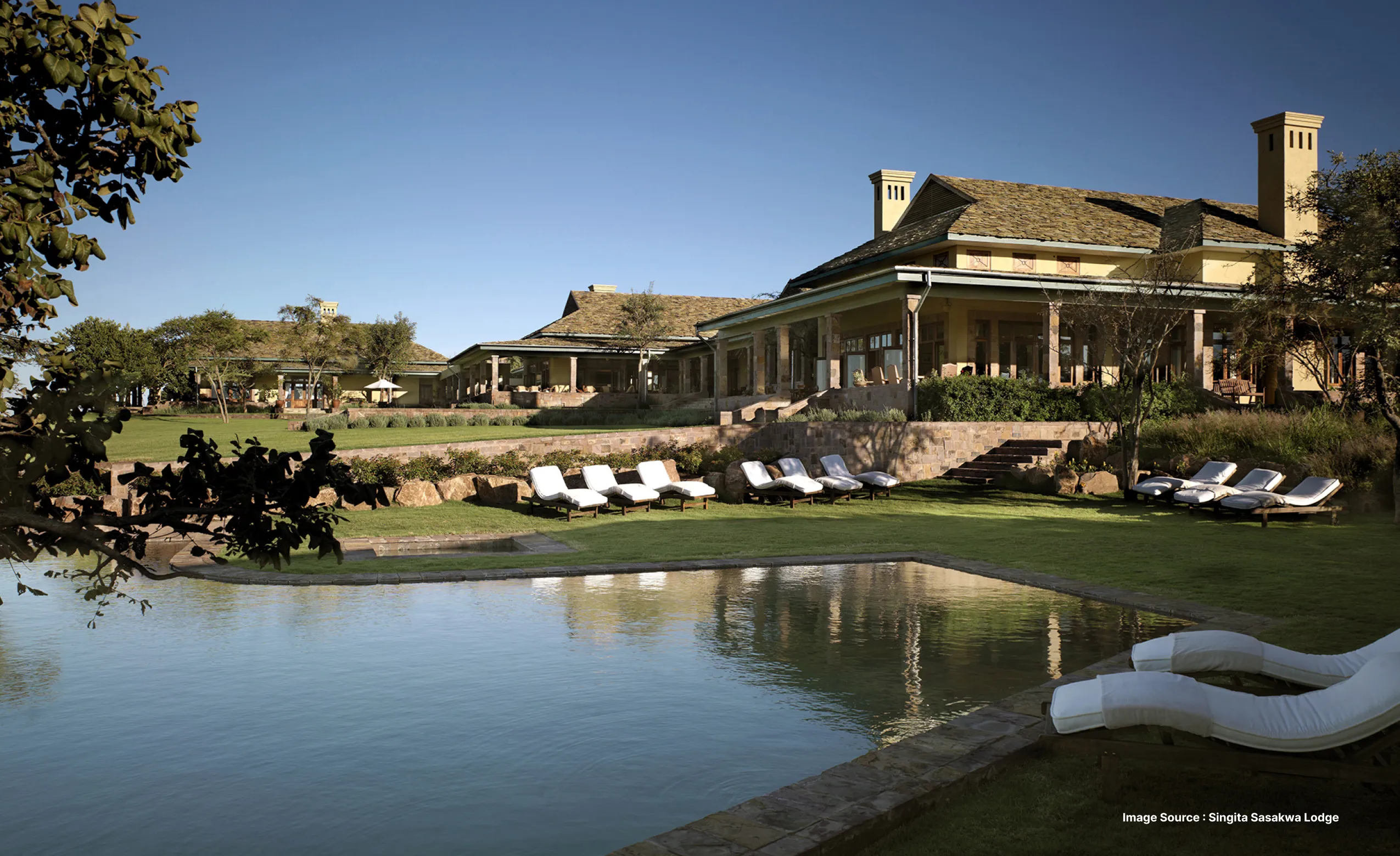 A scenic view with serene pond and beautiful lodges of Singita Sasakwa Lodge of Tanzania