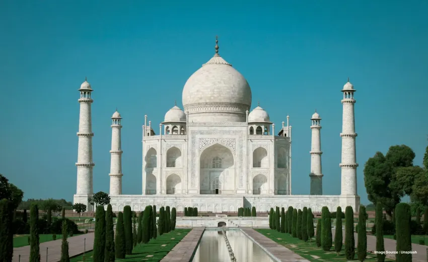 Iconic white marble mausoleum with grand domes, minarets, and perfectly symmetrical gardens.
