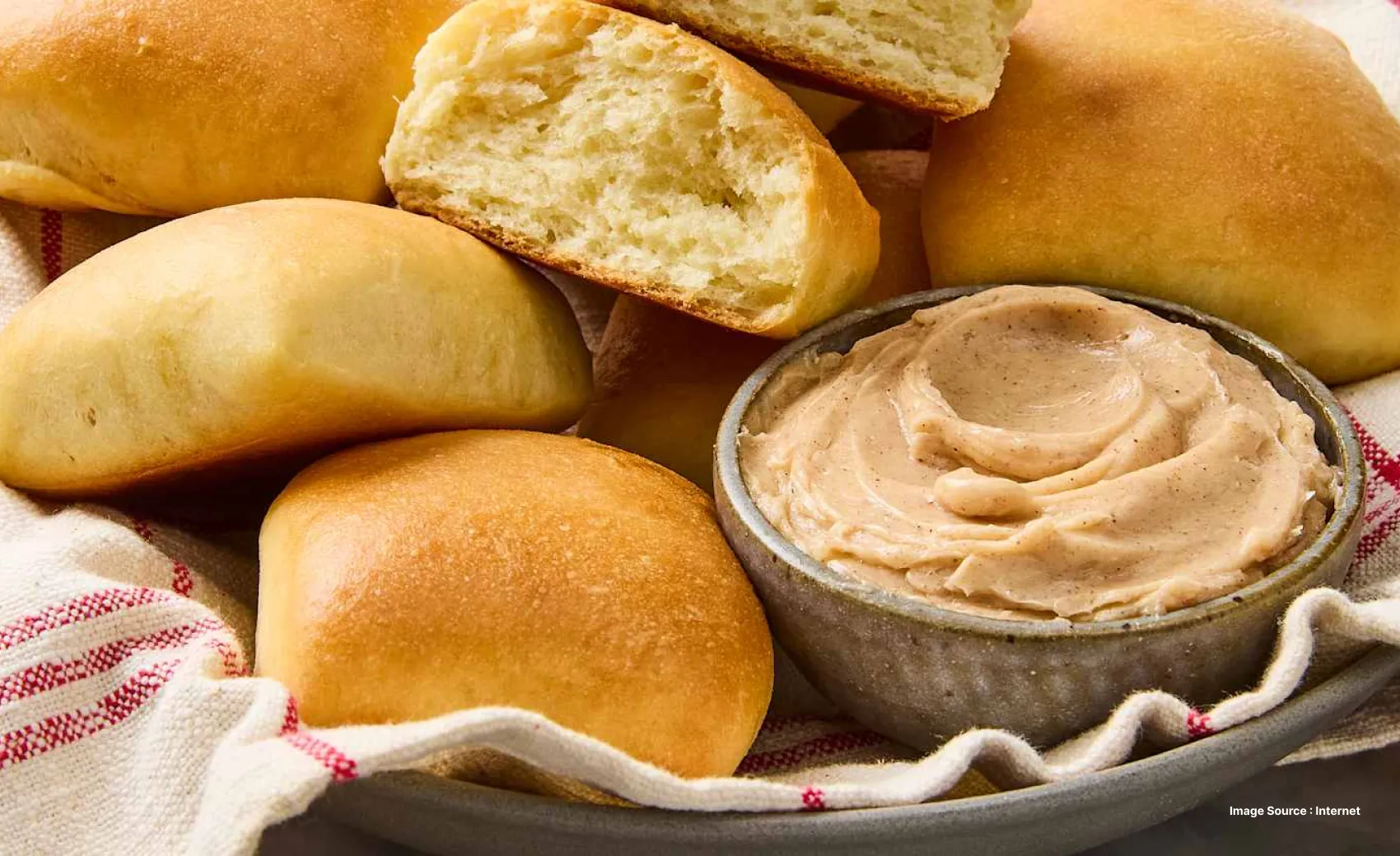 freshly baked rools with cinnamon honey butter dip as one roll is cut inhalf